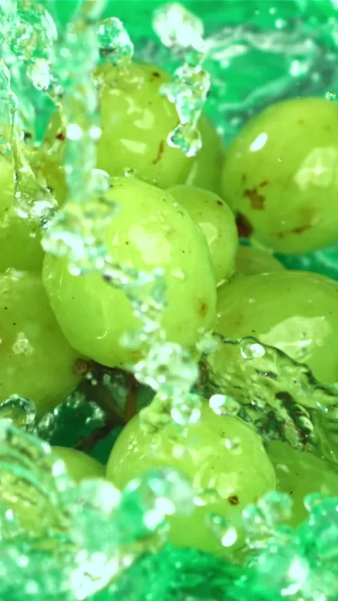 Green grapes fall with splashes into the water. Top view. Filmed on a high-speed Stock Footage 335319088