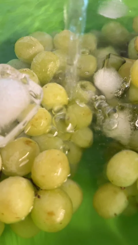 Green Grapes with Ice Cubes in Bubbling Water Close Up Stock Footage 345153238