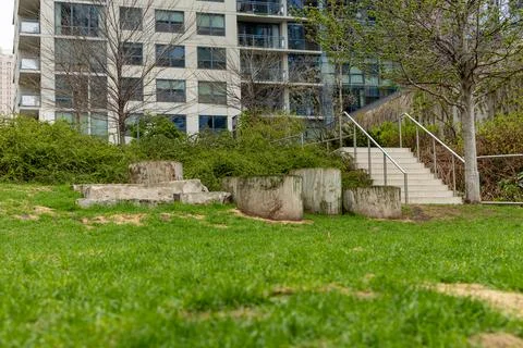 Green grass area with concrete structures and stairs near an apartment buil.. Fotos Stock