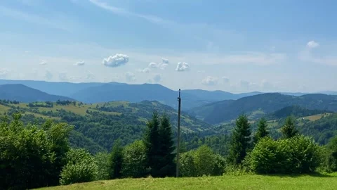 Green grass, clouds, blue sky, mountains, sunny day, green hills, panoramic view Stock-Footage 157784190