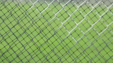 A green grass field through a chain link fence. Stock Footage 68576616