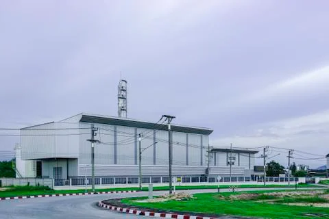 Green grass fields with blur background of industrial factory Stock Photos