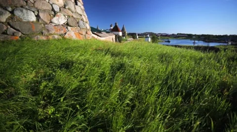 Green grass of glade and tower of Russian Orthodox Solovetsky Monastery. Stock Footage 64929486