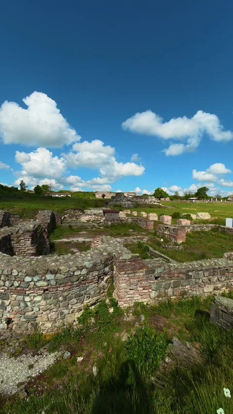 Green grass grows among weathered walls. Felix Romuliana, Vertical POV. Stock Footage 335939194