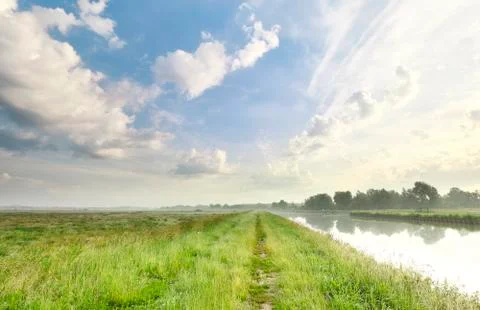 Green grass meadow and beautiful sky Stock Photos