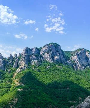 Green grassy mountains under a cloudy sky Stock Photos