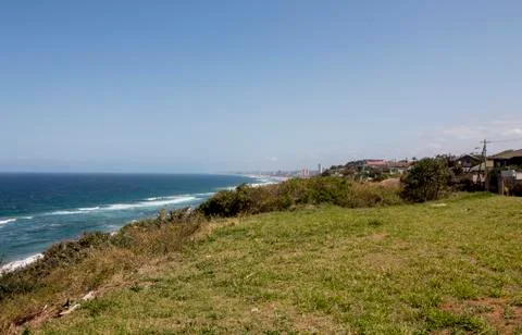 Green Grassy Patch Leading to Steep Slope at Edge of Sea Stock Photos