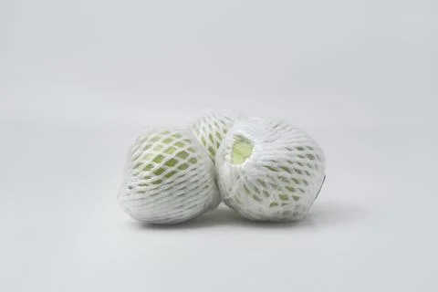 The green guava fruit is covered plastic is on a white background Stock Photos