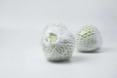 The green guava fruit is covered plastic is on a white background Stock Photos