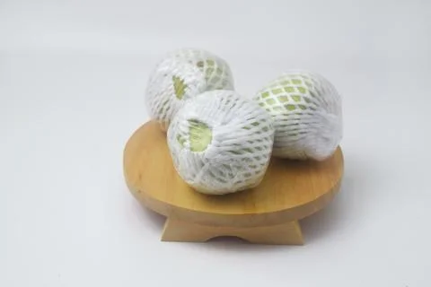 The green guava fruit is covered plastic is on a white background Stock Photos