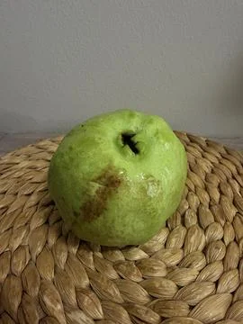 A  green guava on the table with white background Stock Photos