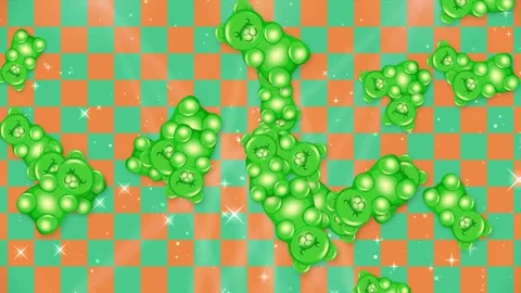 Green Gummy Bears Falling Over Orange and Green Checkered Background Stock Footage 345124934