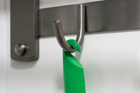Green handle hangs from a metal hook Stock Photos