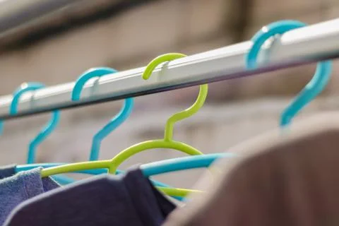 Green hanger Plastic In the clothes array with a blue hanger Plastic. Stock Photos