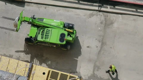 Green Heavy Machinery Operating at the Construction Site. Worker behind Video stock 280689098