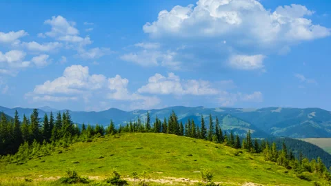 Green hill under a blue cloudy sky Stock Footage 329671505