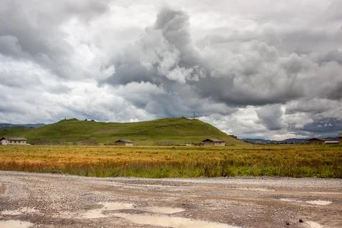 Green hills and dramatic clouds near Shangrila town in Yunnan province, China Illustrazione stock