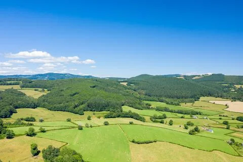 Green hills and patchwork fields under blue sky Stock Photos