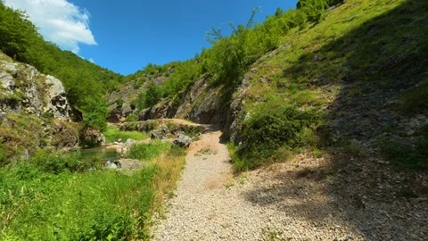 Green hills frame a clear, flowing stream. Gradasnica River Canyon, Serbia Stock Footage 342320071