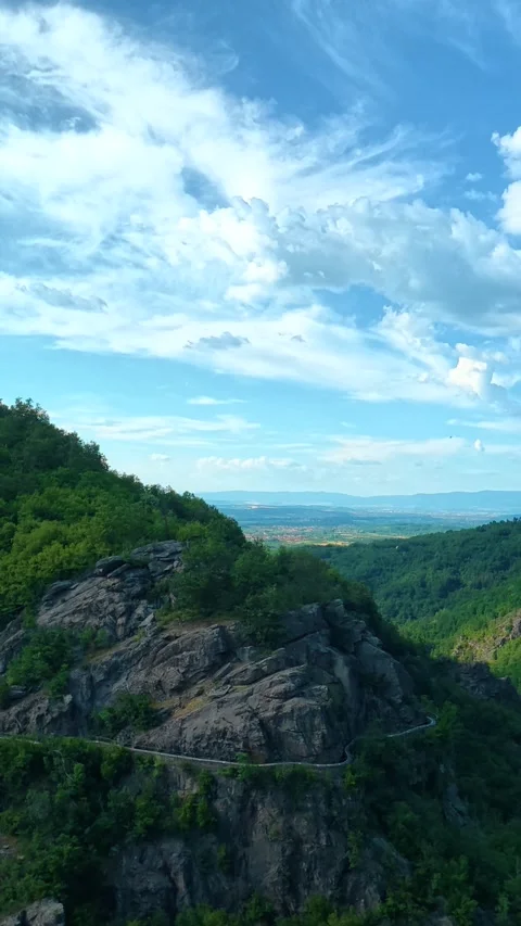 Green hills roll beneath a vast, blue sky. Sokolica rock, Serbia. Vertical Stock Footage 341132780