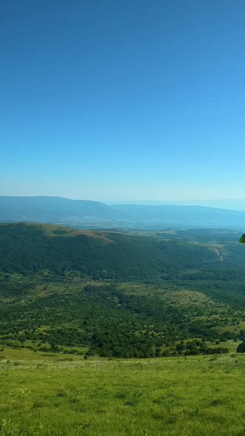 Green hills roll under clear blue skies. Mount Rtanj, Serbia. Vertical 库存影片 342318605