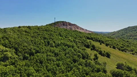 Green hills with trees and a tower in the distance under a clear sky Stock Footage 338276016