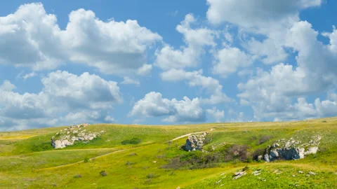 Green hills under a dense cloudy sky Stock Footage 327798362