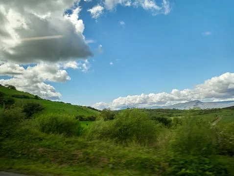 Green hills under dramatic blue sky Фото