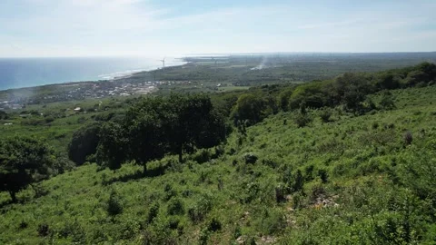 Green hillside with a flat coastal town in the distance, aerial view Stockbeeldmateriaal 278370177