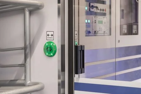 A green illuminated button labeled automatic on a modern passenger train door, 스톡 사진