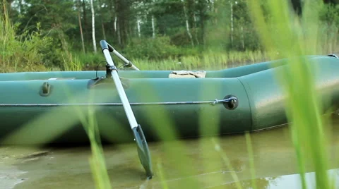 Green inflatable boat standing on the beach with their oars. moving the camera Stock Footage 66203246