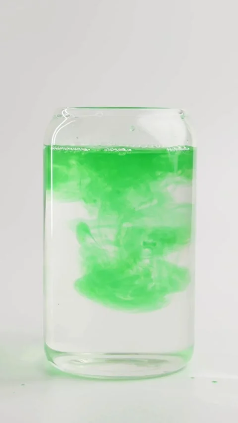 Green ink pours into water creating a large cloud Stock Footage 331774695