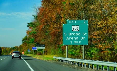 This is a green interstate guide sign on a highway announcing Exit 2 for U... Stock Photos