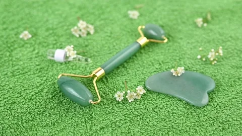 Green jade roller face massager with golden elements Stock Footage 130460101