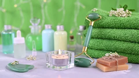 Green jade roller at large towels between candle and soap Stock Footage 133053469