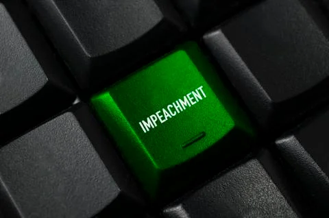 A green key on a black computer keyboard with the word impeachment Stock Photos