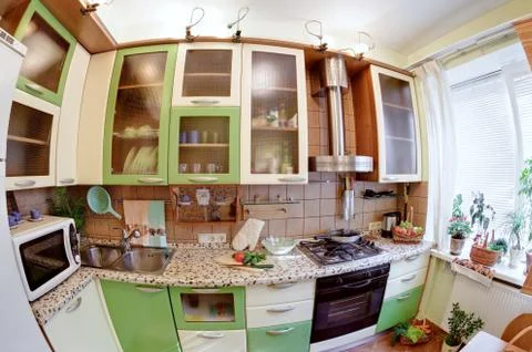 Green kitchen interior with many utensils and window, fisheye view Foto stock