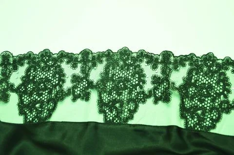 Green lace with an openwork beautiful pattern of fabric texture. An element o Stock Photos