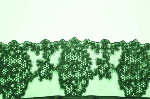 Green lace with an openwork beautiful pattern of fabric texture. An element.. Stock Photos