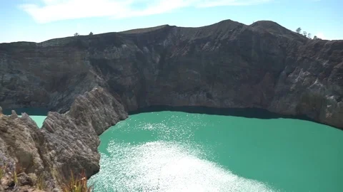 Green lake at Kelimutu - pan left and tilt down Stock Footage 87585958
