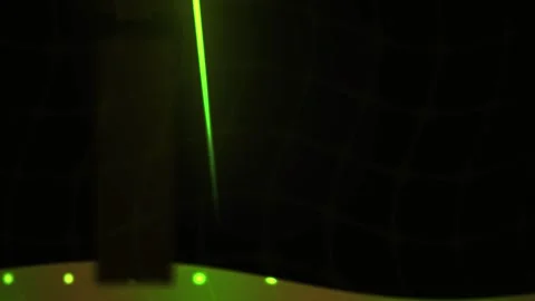 Green laser beam shining through a dark grid structure with glowing dots. Stock Footage 337514677