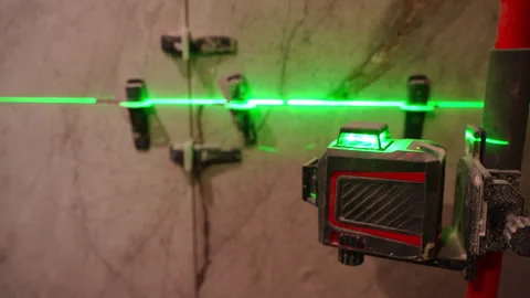 Green laser level close-up with wall tile spacers Stock Footage 302197407