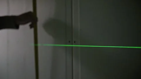 Green laser level projecting line on wall for measurements Stock Footage 314058780