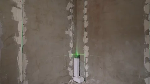 Green laser level tool projecting lines on walls during renovation Stock Footage 308247206