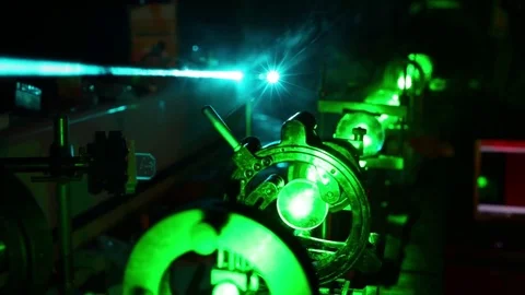 Green laser in optic assembly and bright blue laser above in dark close up. Stock Footage 69988901