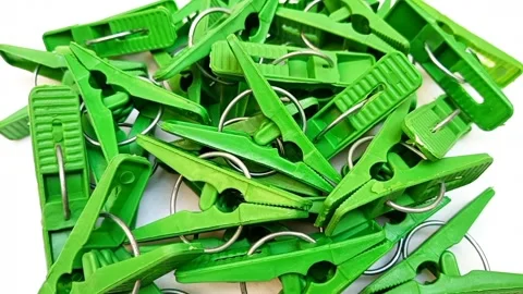 Green laundry clips rotating on the white background, plastic clothes pins .. Stock Footage 306200308