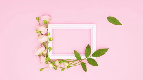 Green leaf falling on romantic decoration of roses and white frame. Stop motion Stock Footage 137867890