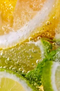 Green leaf of mint, pieces of lemon and lime with bubbles in a transparent .. Stock Photos