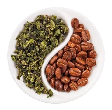 Green leaf tea versus coffee beans in yin yang shaped plate, isolated on whit Stock-Fotos