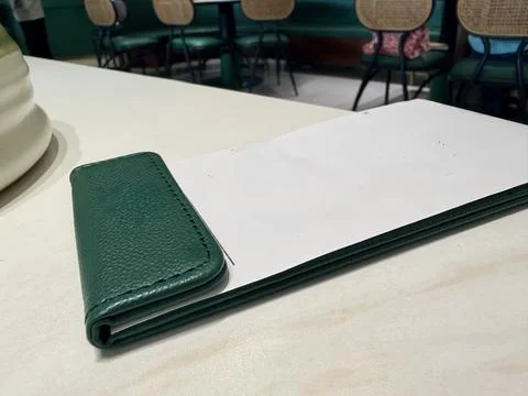 Green leather notebook on a white table. Stock Photos